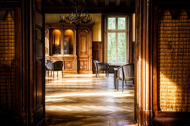 Empty room with wooden floors and paneling, minimal furnishings creating natural acoustic resonance